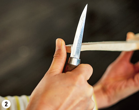 親指を刃の進行方向から逃して材料の端に当て、残りの指でナイフの柄を握ります。拳を握る力でナイフを引いて削ります。