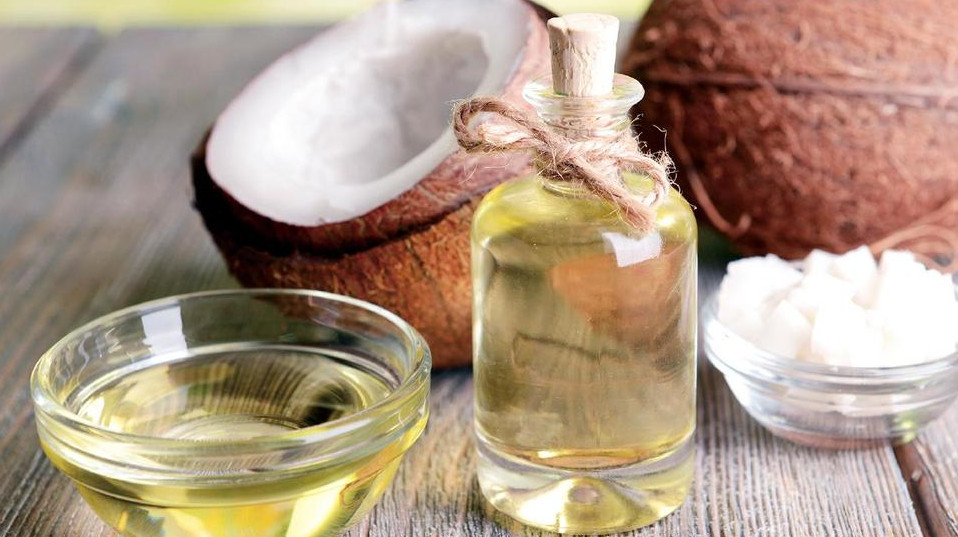 液状のココナッツオイルとココナッツ。近年は固まらない液状の「リキッドココナッツオイル」もあります。