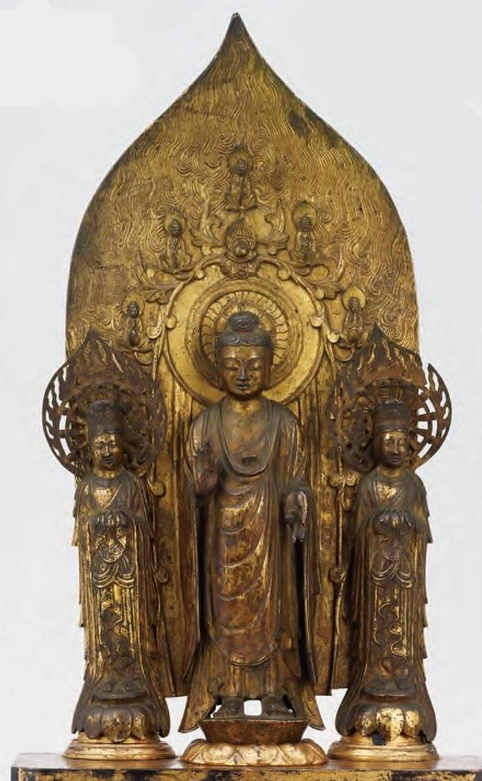 銅製の仏像で、三体とも舟形光背に包み込まれる「一光三尊」形式。6~7世紀に朝鮮半島の百済から伝来したものと考えられます。善光寺式阿弥陀三尊との共通点も多い作品。像高は28.1cm(中尊)。